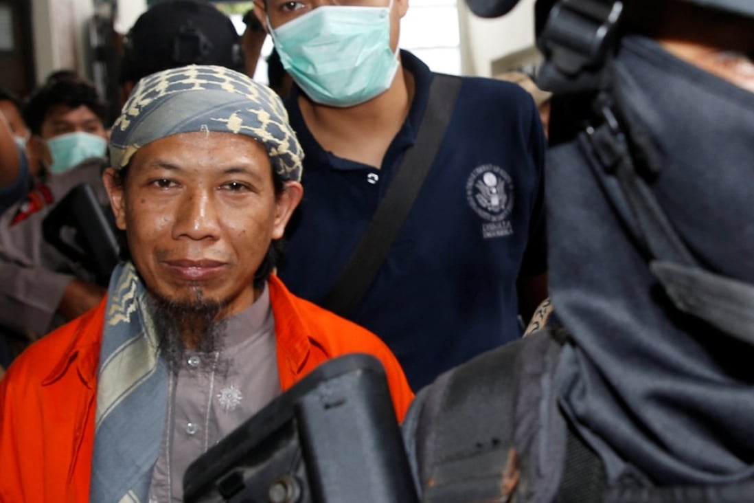 Policemen lead Islamic cleric Aman Abdurrahman to the courtroom for his trial in Jakarta. Photo: Reuters