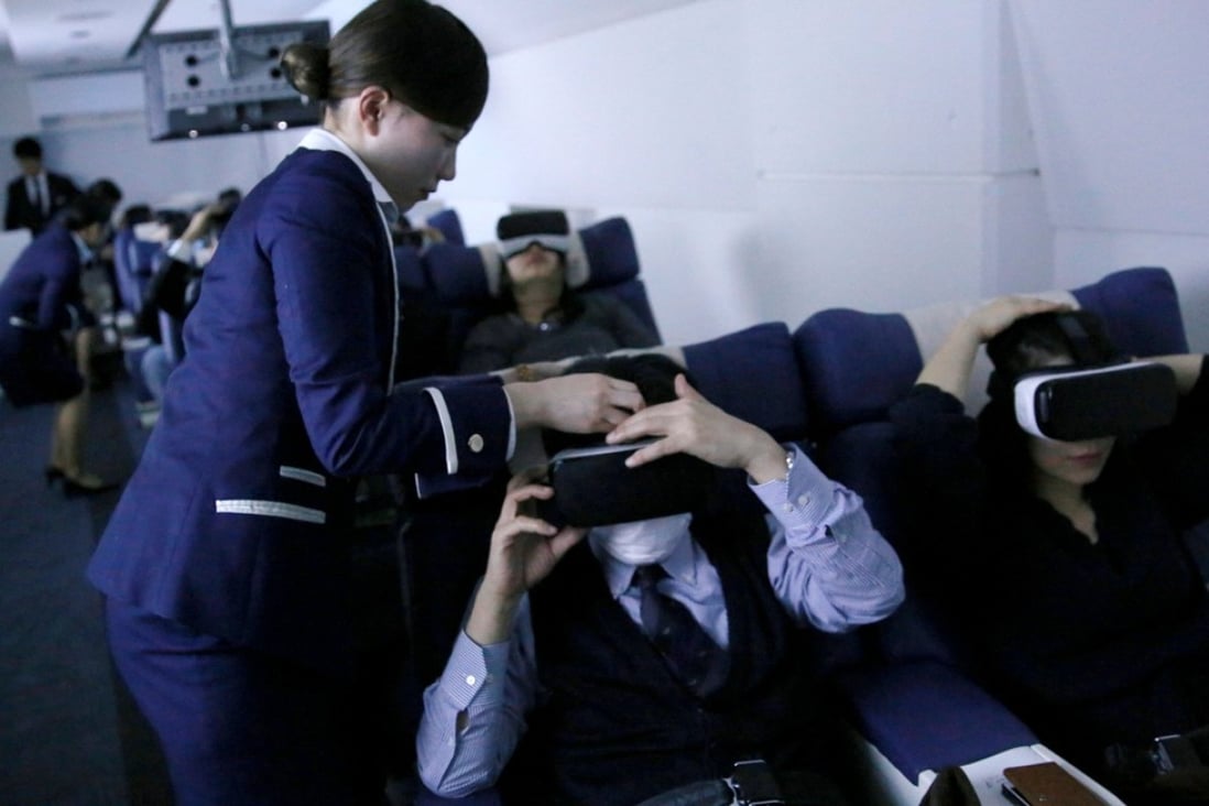 Staff dressed as flight attendants help guests to put on virtual reality goggles at First Airlines in Tokyo. Photo: Reuters