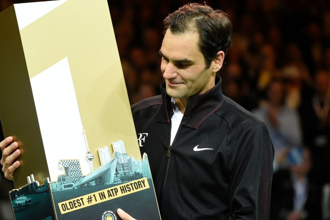 Roger Federer holds a trophy celebrating his milestone achievement after beating Robin Haase in their Rotterdam quarter-final. Photo: AFP