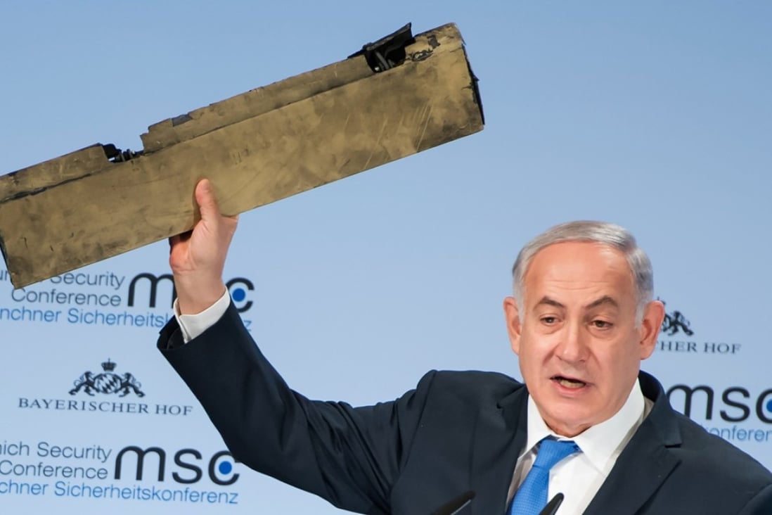 Israeli Prime Minister Benjamin Netanyahu holds up what he said was wreckage from an Iranian drone shot down in Israeli airspace as he gives a speech during the Munich Security Conference on Sunday. Photo: Agence France-Presse