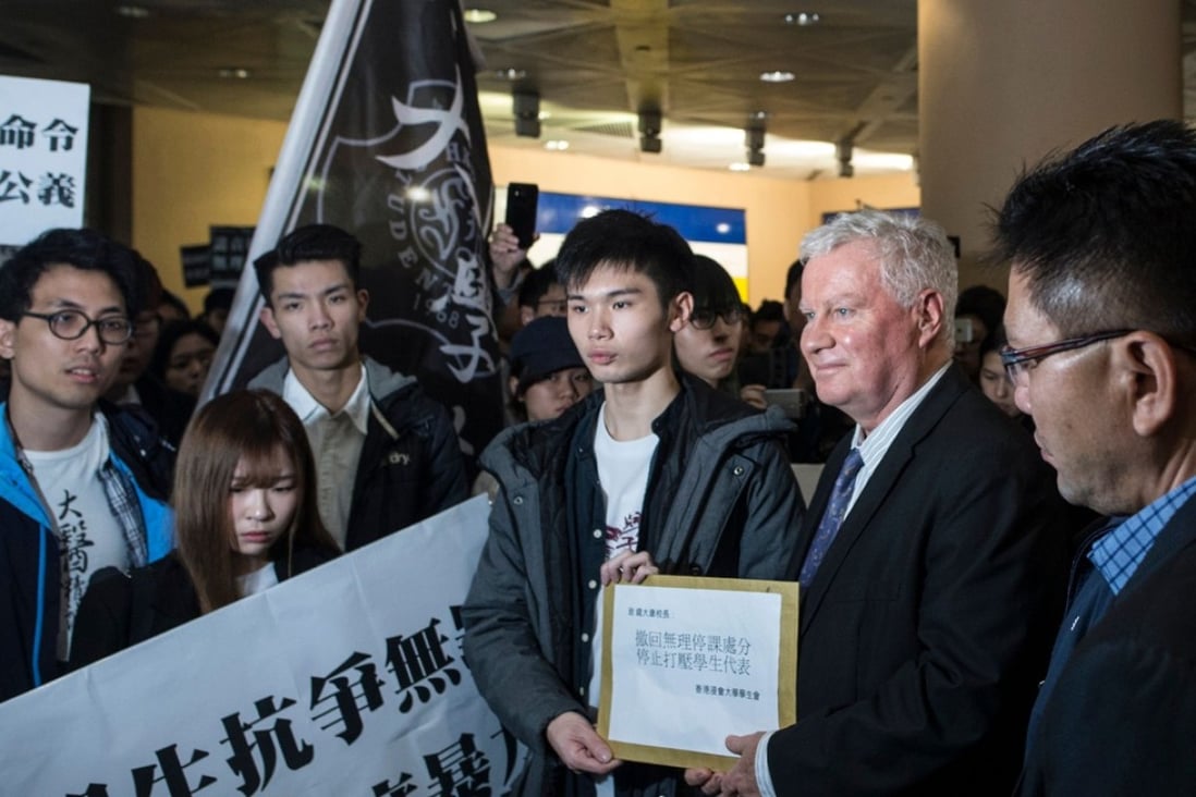 Clayton MacKenzie (second right), a representative of Baptist University, receives a petition letter from a student demonstrator, in Hong Kong on January 26. Hundreds of students protested on the day amid tensions over compulsory testing of Mandarin, the dominant language in mainland China, for graduation. Photo: AFP