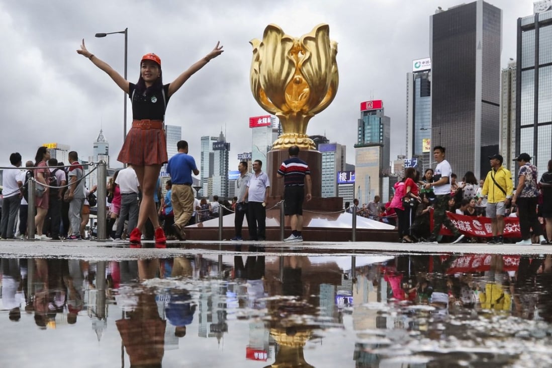 Visitors at Golden Bauhinia Square in Wan Chai, a popular tourist attraction on Hong Kong Island. Photo: Felix Wong