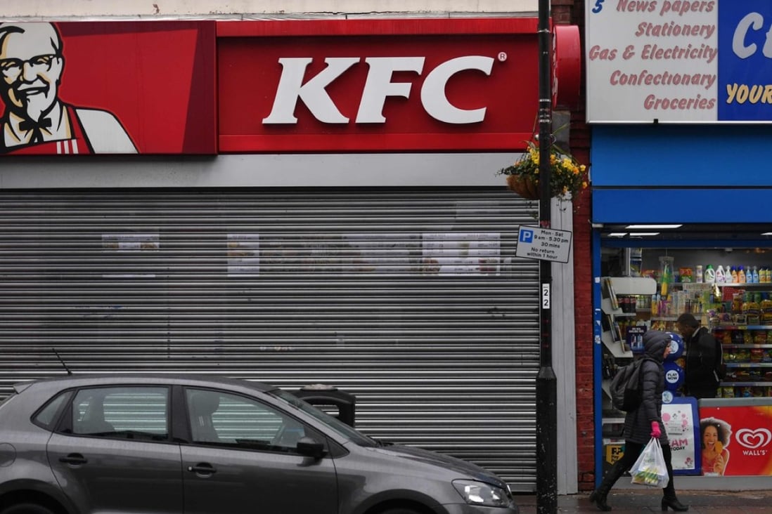 Pedestrians walk past a closed KFC fast food store in south London on February 19. Photo: AFP