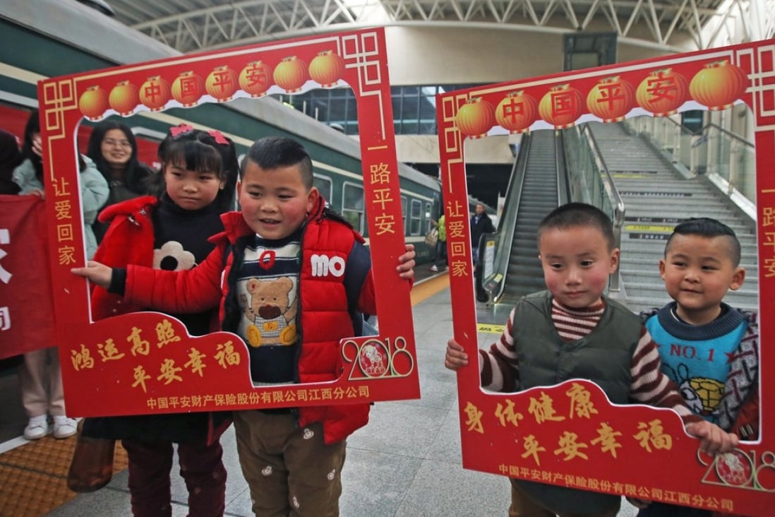 Children of migrant workers pose for photos before the departure of a train from Shantou in Guangdong Province en route to Nanchang, Jiangxi Province on February 10. About 2,800 migrant workers and their relatives took the train that day for family reunion during the Spring Festival. Photo: Xinhua