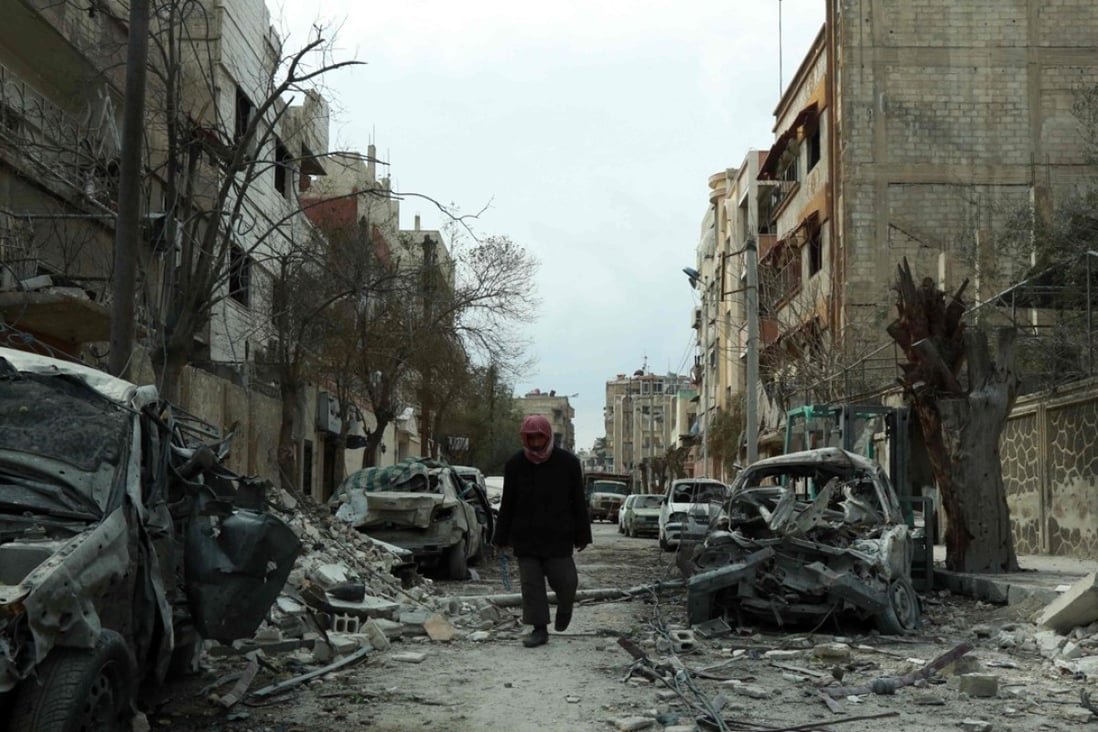 A man walking next to damaged buildings following air strikes in the Syrian rebel-held town of Douma. Photo: AFP