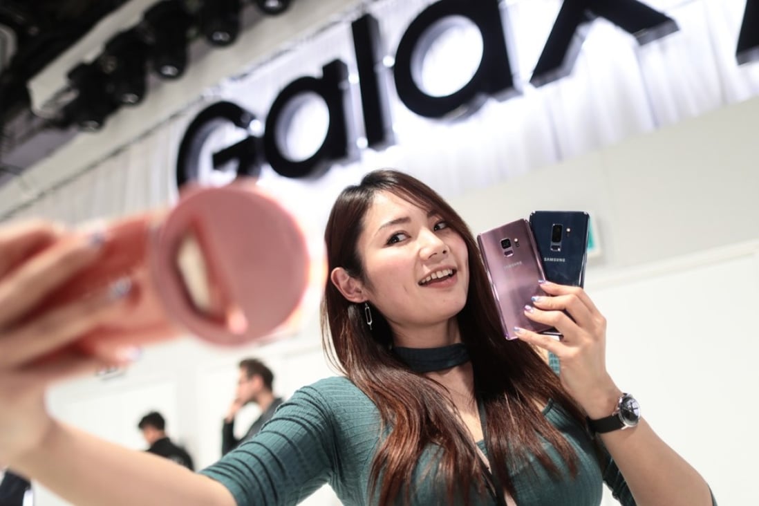 An attendee takes a 'selfie' photograph holding a pair of Galaxy S9 smartphones during a Samsung Electronics Co. 'Unpacked' launch event ahead of the Mobile World Congress (MWC) in Barcelona, Spain, on Sunday, Feb. 25, 2018. Photo: Bloomberg