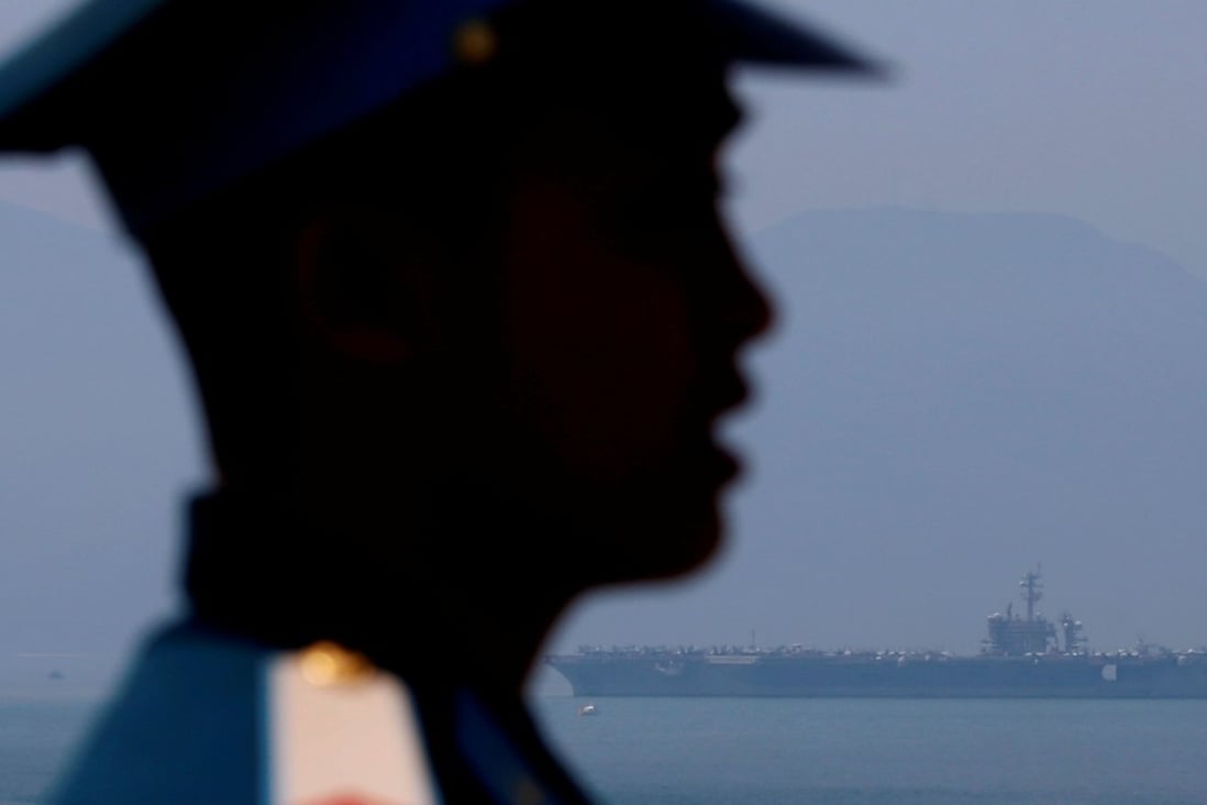 A Vietnamese soldier keeps watch as aircraft carrier USS Carl Vinson arrives at a port in Da Nang. Photo: Reuters