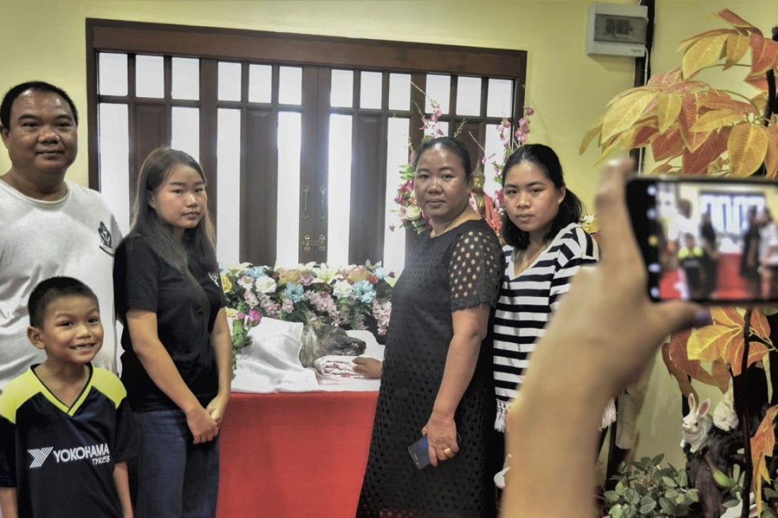 Members of the Suwan family pose for a photo with the remains of Beckham, their beloved canine companion in Bangkok, Thailand. Photo: Tibor Krausz