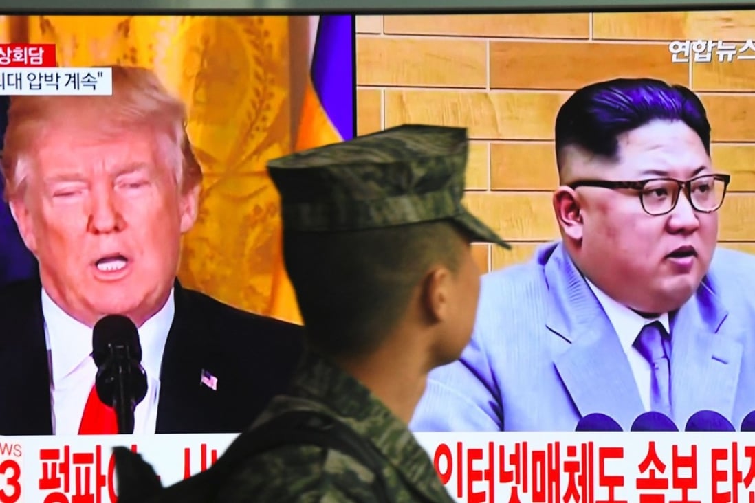A South Korean soldier walks past a television screen showing pictures of US President Donald Trump and North Korean leader Kim Jong-un. The two heads of state are expected to meet in May. Photo: AFP