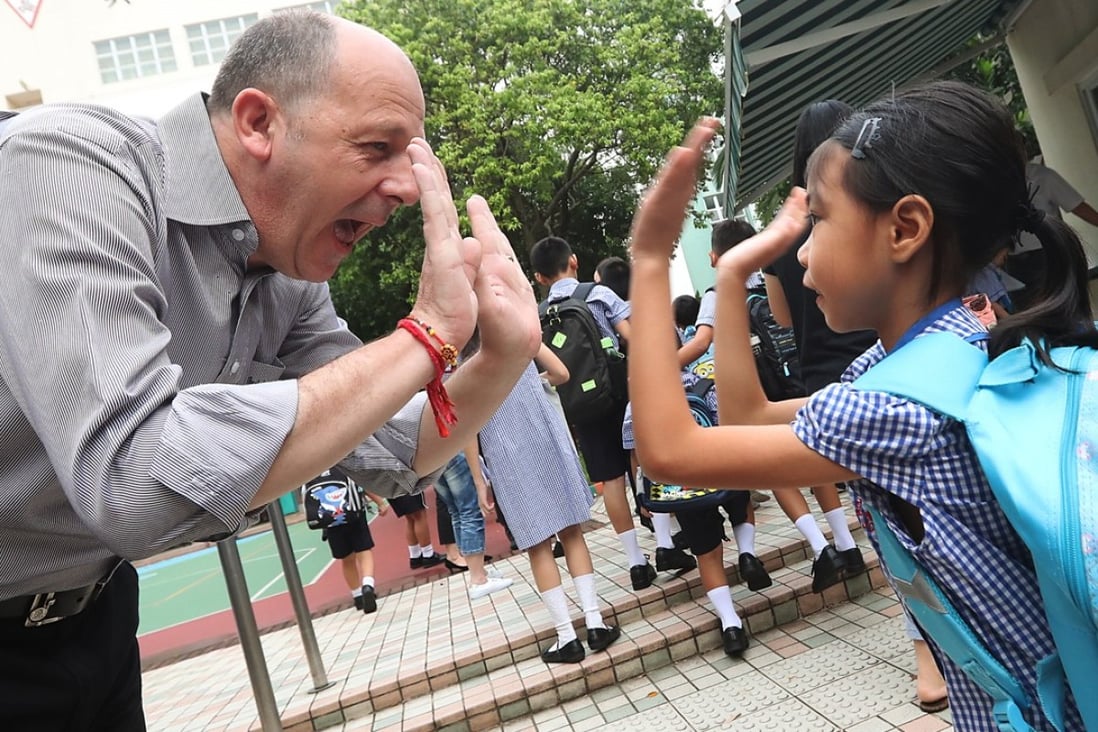 A teacher welcomes his students on the first day of school at Hing Tak School in Tuen Mun. Some recent test results may be an indicator of improving English standards among Hong Kong’s youth. Photo: Edward Wong