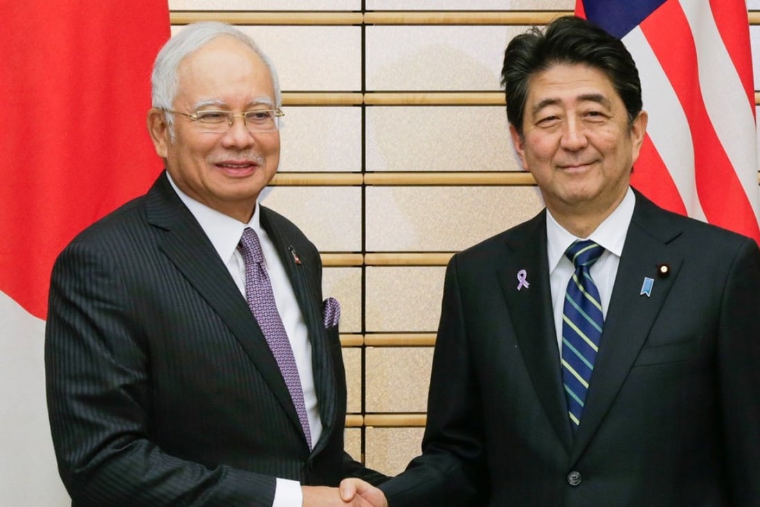 Malaysian Prime Minister Najib Razak (left) shakes hands with Japanese Prime Minister Shinzo Abe at the start of their meeting at Abe's residence in Tokyo in 2016. Photo: Reuters