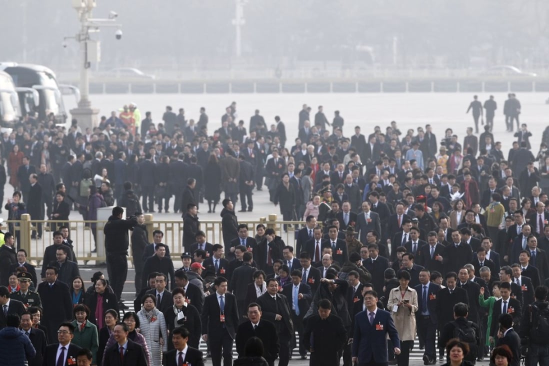Delegates to the National People’s Congress walk through a haze of pollution in Tiananmen Square on Tuesday. Photo: AP