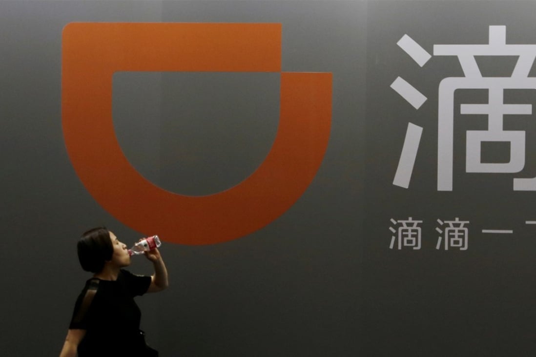 A woman walks past Didi Chuxing's booth at the Global Mobile Internet Conference in Beijing. Photo: Reuters 