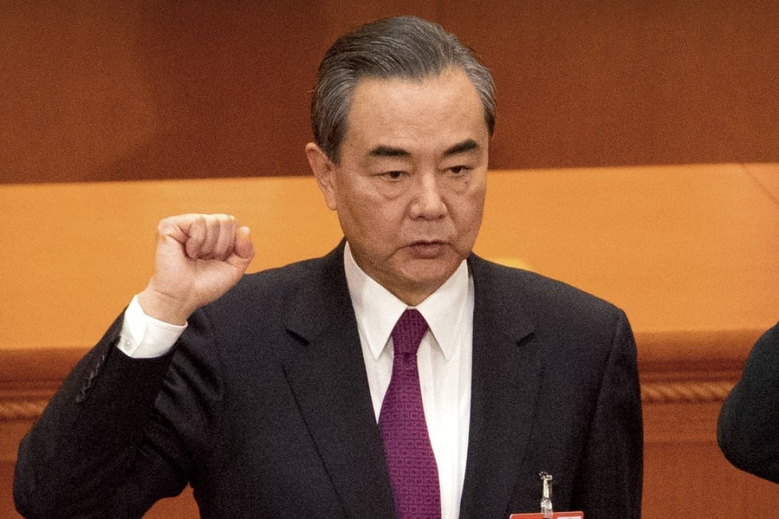 Foreign Minster and newly-appointed State Councillor Wang Yi takes the oath of office at the Great Hall of the People in Beijing on Monday. Photo: AP