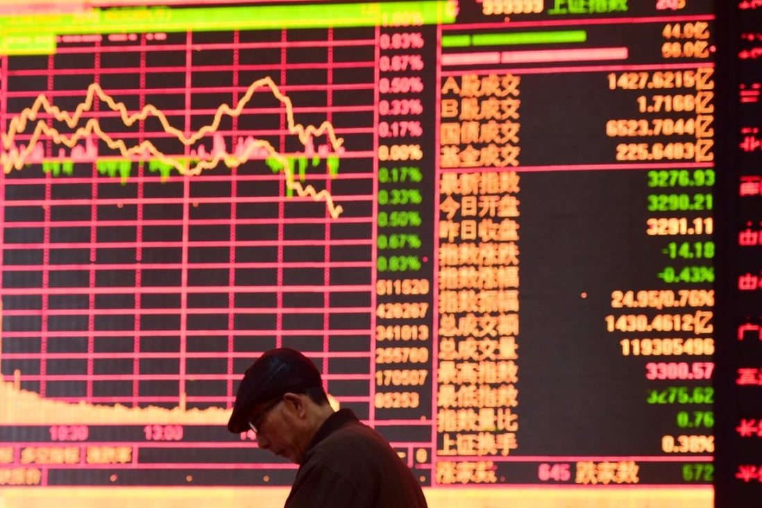 A man against an electronic board showing stock information at a brokerage house in Fuyang, Anhui province. Contrary to global conventions, China denotes gains and increases in red, and uses green to denote declines and losses. Photo: REUTERS/Stringer