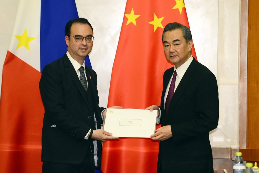 Philippine Foreign Affairs Secretary Alan Peter Cayetano (left) gives Chinese Foreign Minster Wang Yi a handwritten letter from President Rodrigo Duterte to President Xi Jinping before their meeting in Beijing on March 21. Photo: EPA-EFE