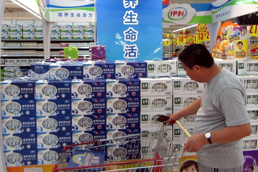 A man looks at Yili products at a store in Shanghai in this file image. The dairy company said its chairman and CEO Pan Gang was being treated for a heart condition overseas and would not be able to attend the Boao Forum for Asia as planned. Photo: Imaginechina