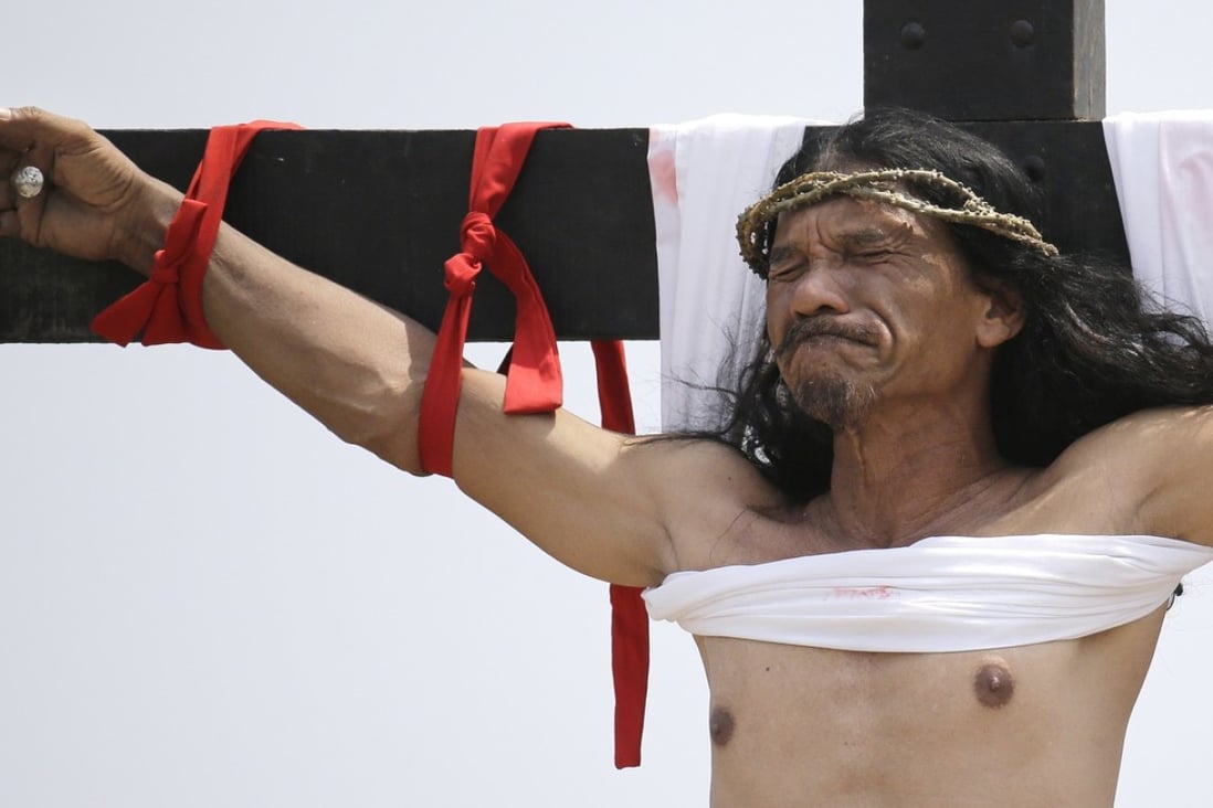 Ruben Enaje reacts after he was nailed to the cross for the 32nd year in a row during a re-enactment of Jesus Christ's sufferings as part of Good Friday rituals in the village of San Pedro Cutud, Pampanga province, northern Philippines. Photo: AFP