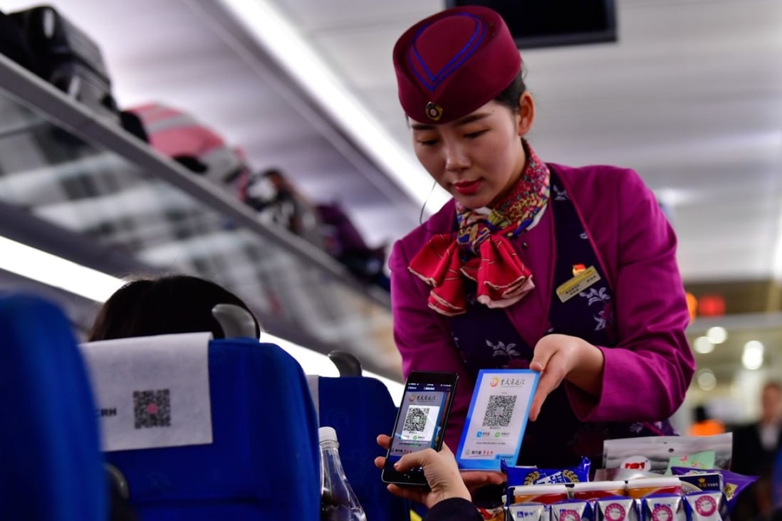 A passenger buys bottled water by scanning a QR code on a train from Chongqing to Chengdu. Making payments using a mobile phone is one of the most easily recognisable impacts of fintech in people’s daily lives. Photo: Xinhua