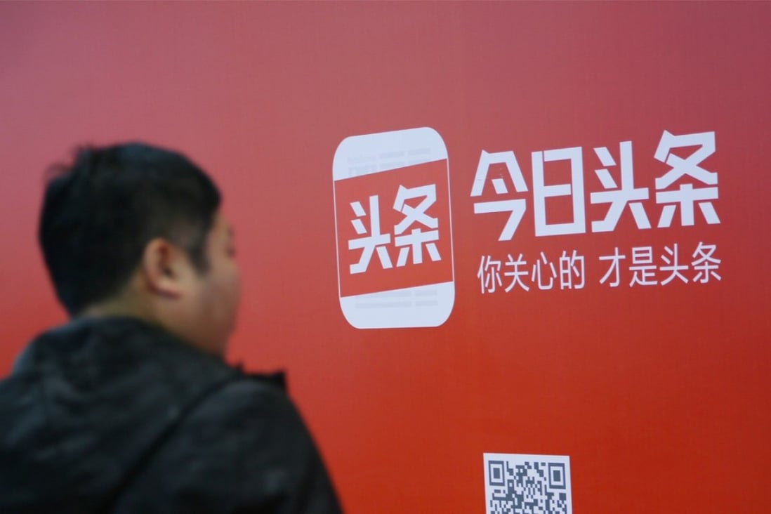 A man walks past an advertisement of Bytedance's news feed platform Toutiao, in Beijing. 