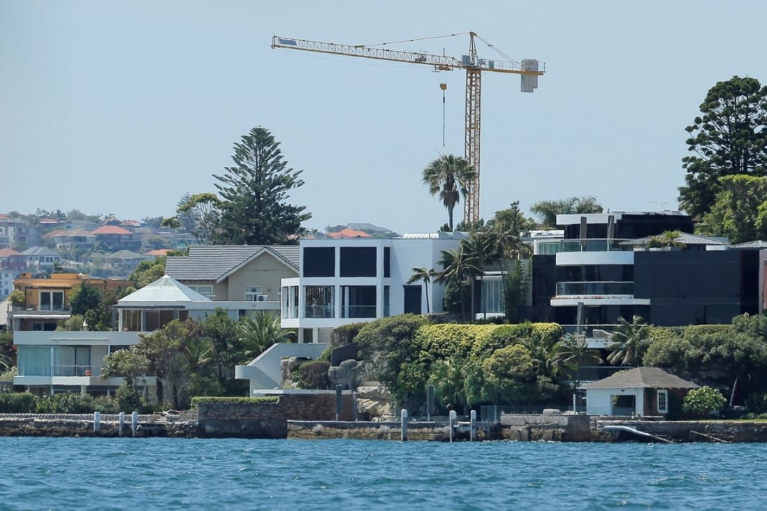 A construction tower appears over waterfront property on Sydney Harbour in Australia, where prices fell 2.1 per cent in March year on year. Photo: Reuters