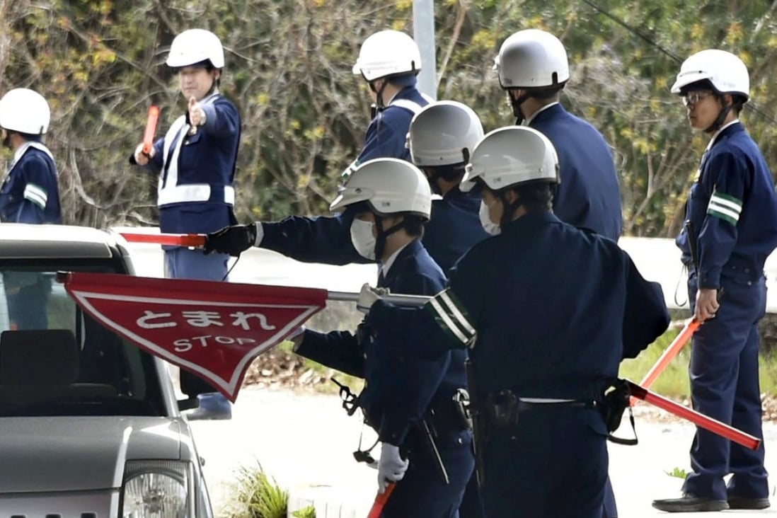 Japanese police inspect cars in Onomichi as they search for a jail breaker. Photo: AP