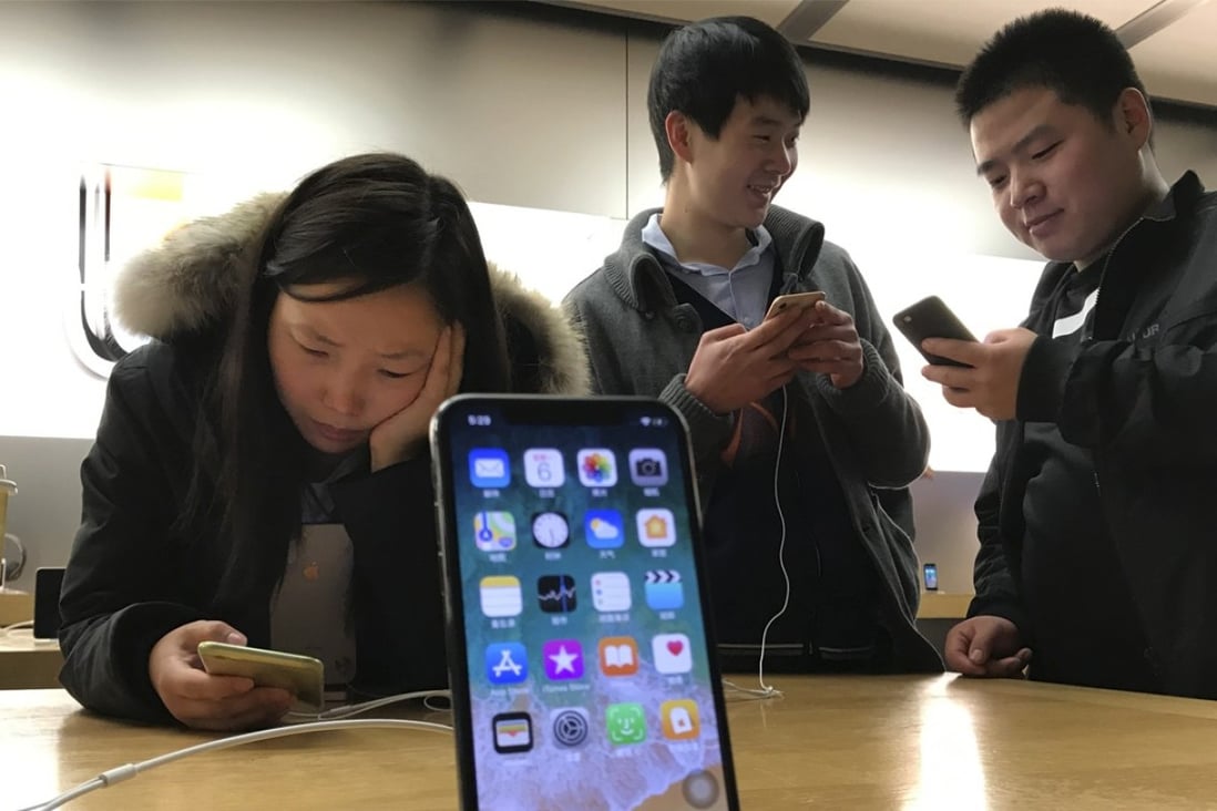 Shoppers check out the iPhone X at an Apple store in Beijing, China. Photo: AP