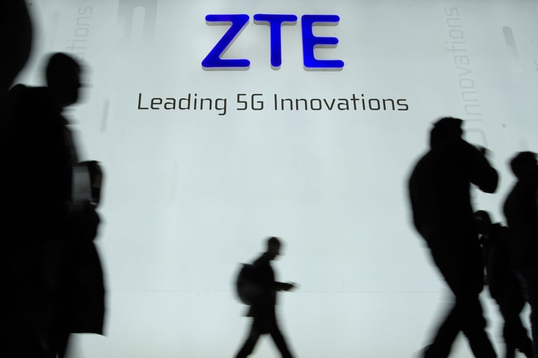 (FILES) This file picture taken on February 27, 2018 shows people walking in front of the ZTE stand at the Mobile World Congress (MWC), the world's biggest mobile fair, in Barcelona. Chinese telecom giant ZTE halted trading of its shares in Hong Kong and Shenzhen on April 17, 2018 following the announcement of a US ban on its purchase of sensitive technology that drew a pledge from China to "safeguard" its companies if necessary. / Photo: Agence France-Presse