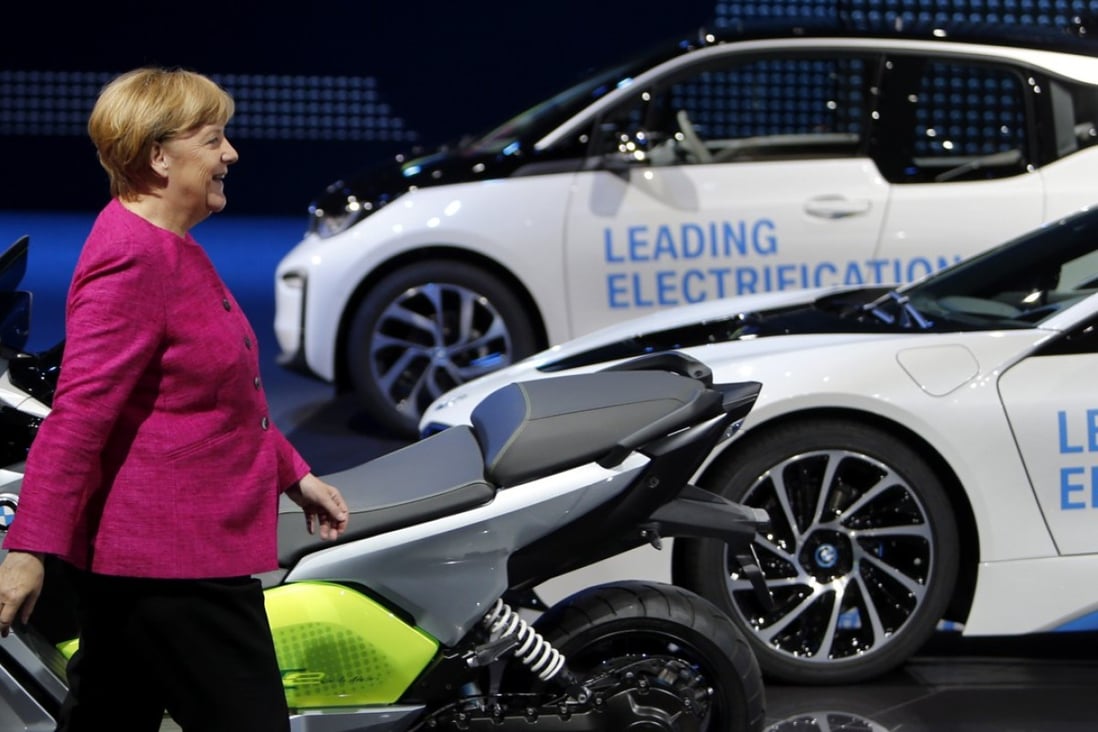 German Chancellor Angela Merkel walks past electricity-powered vehicles at the booth of the German car manufacturer BMW during her visit to the Frankfurt Auto Show in September 2017.  Recent indicators show that German manufacturing growth is slowing in 2018. Photo: AP 