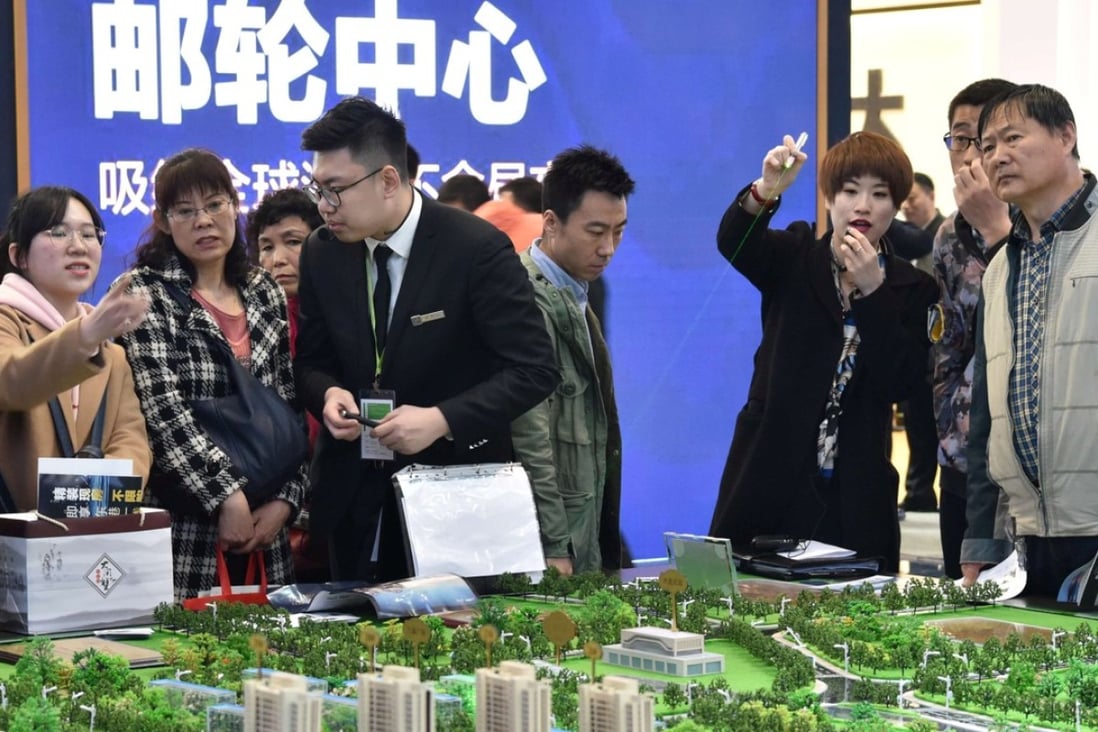 Sales staff and potential buyers at a property fair in China. Developers are less optimistic about sales growth this year as government curbs and higher mortgage rates bite. Photo: Reuters