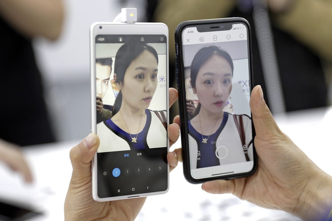 An attendee holds the Xiaomi Mi MIX 2S smartphone (left) next to an Apple iPhone X while testing their front-facing cameras at an event in Shanghai on March 27, 2018. Xiaomi unveiled its latest top-tier smartphone to bring the fight to Apple and Samsung, as the Chinese start-up prepares for a highly anticipated IPO. Photo: Bloomberg