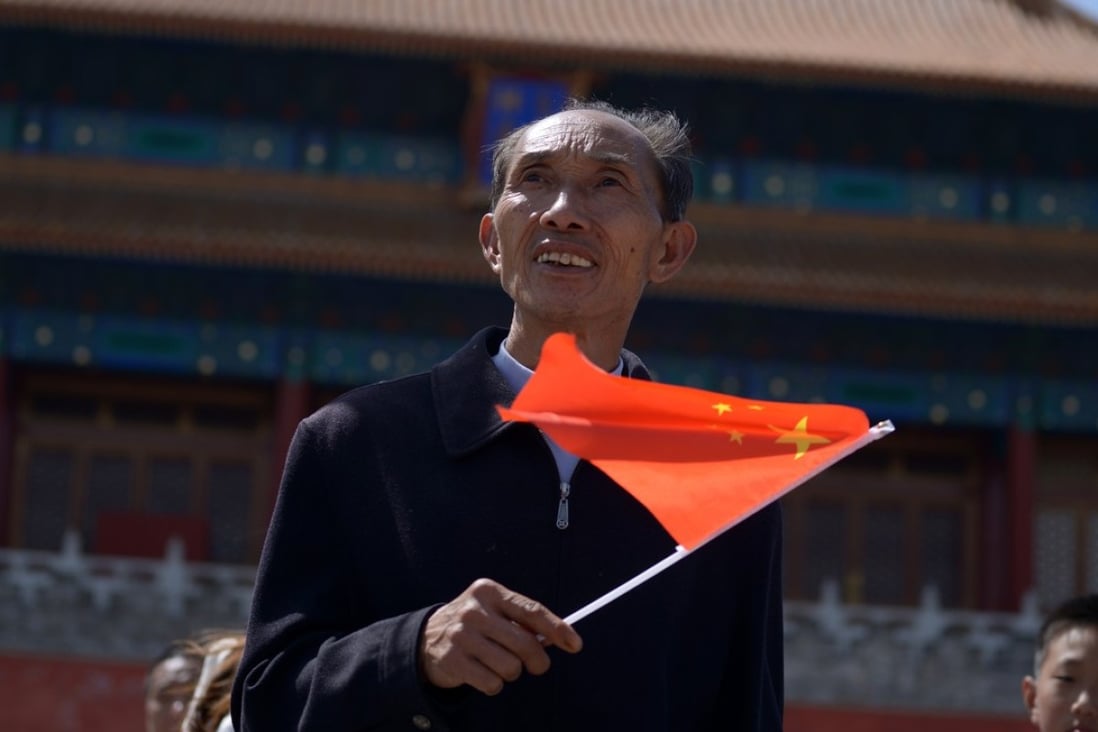 A man waves a Chinese flag after visiting the Forbidden City in Beijing in May 2015. Photo: AFP 