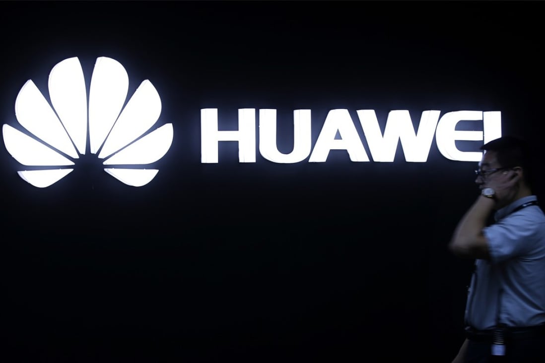 A man walks past a Huawei logo during a launch event for the Huawei Matebook in Beijing in 2016. Huawei is making bitcoin easier to access on its phones. Photo: AP