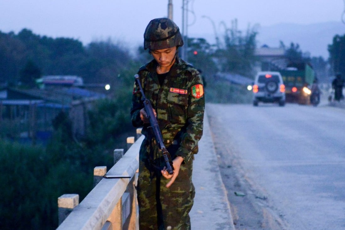 A militiaman linked to the Malaysian army stands on a bridge in Muse. China on Sunday condemned fighting on its border between Myanmar forces and ethnic rebels that left 19 people dead, most of them civilians. Photo: AFP