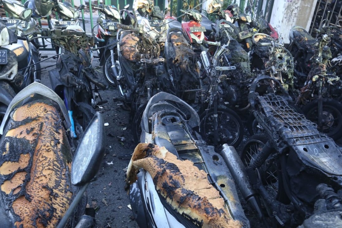 Burnt-out motorcycles sit on the street following a bomb blast outside the Surabaya Centre Pentecostal Church in Surabaya, East Java province. Photo: AFP