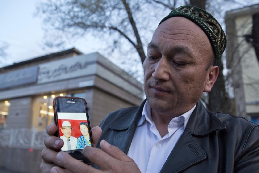 Omir Bekali holds up a mobile phone showing a photo of his parents whom he believes have been detained in China’s western Xinjiang region. Photo: AP