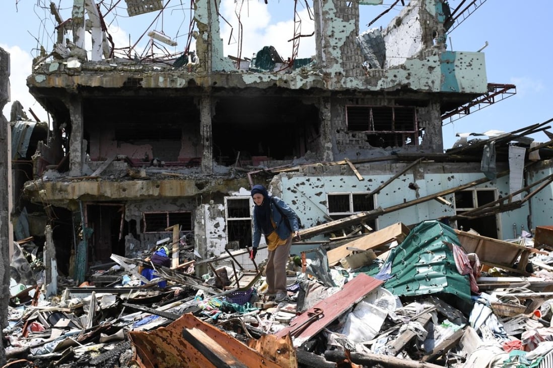 A Marawi resident stands on top of piles of rubble, the remains of her house, as she tries to salvage personal items. The city was destroyed by months of conflict between Islamic militants and the Philippine armed forces. Photo: AFP