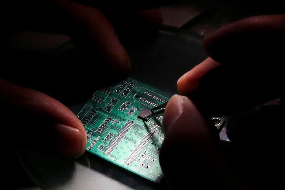 A researcher planting a semiconductor on an interface board during a research work to design and develop a semiconductor product at Tsinghua Unigroup research centre in Beijing on February 29, 2016. Photo: Reuters