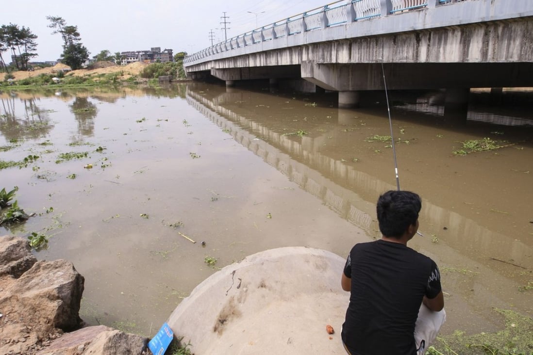 A flle picture of a man fishing in a flooded river in Yongkang in eastern Zhejiang province. Photo: Simon Song