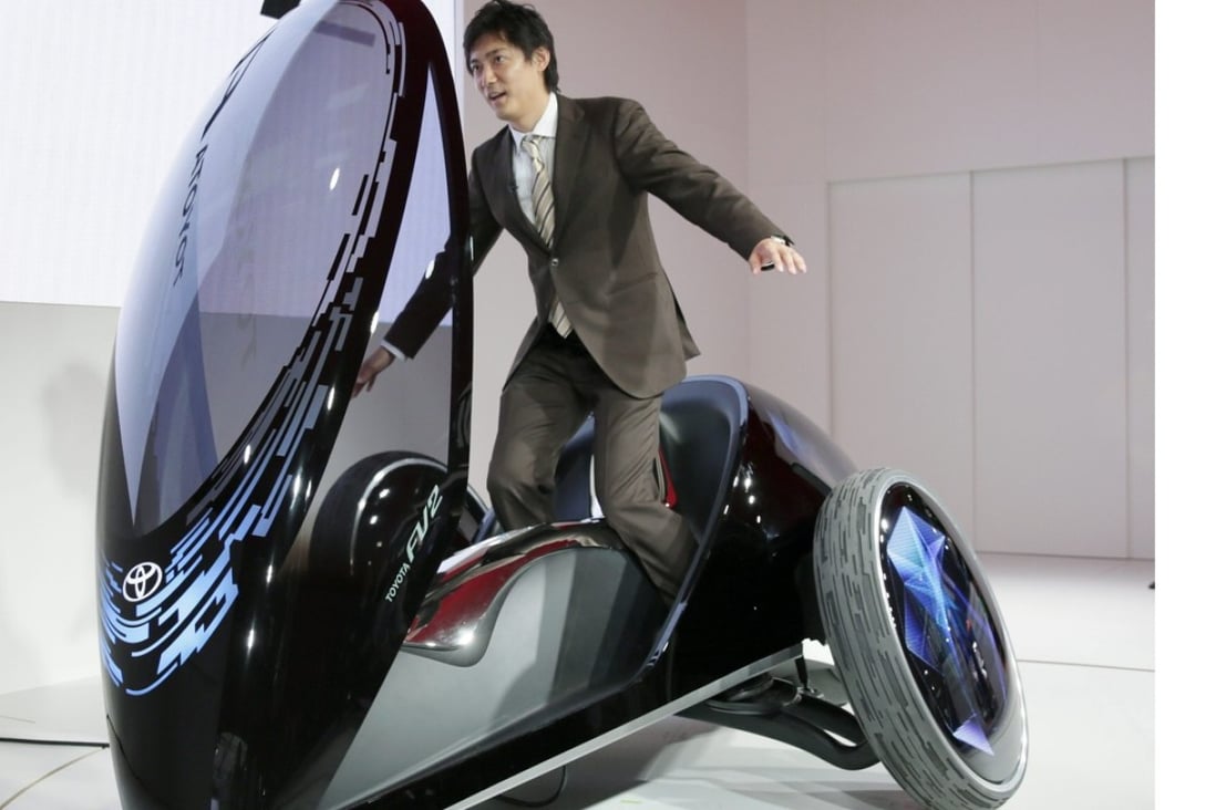 A TV reporter tries to control a Toyota Motor Corp. Toyota FV two in Tokyo, Japan. Photo: EPA