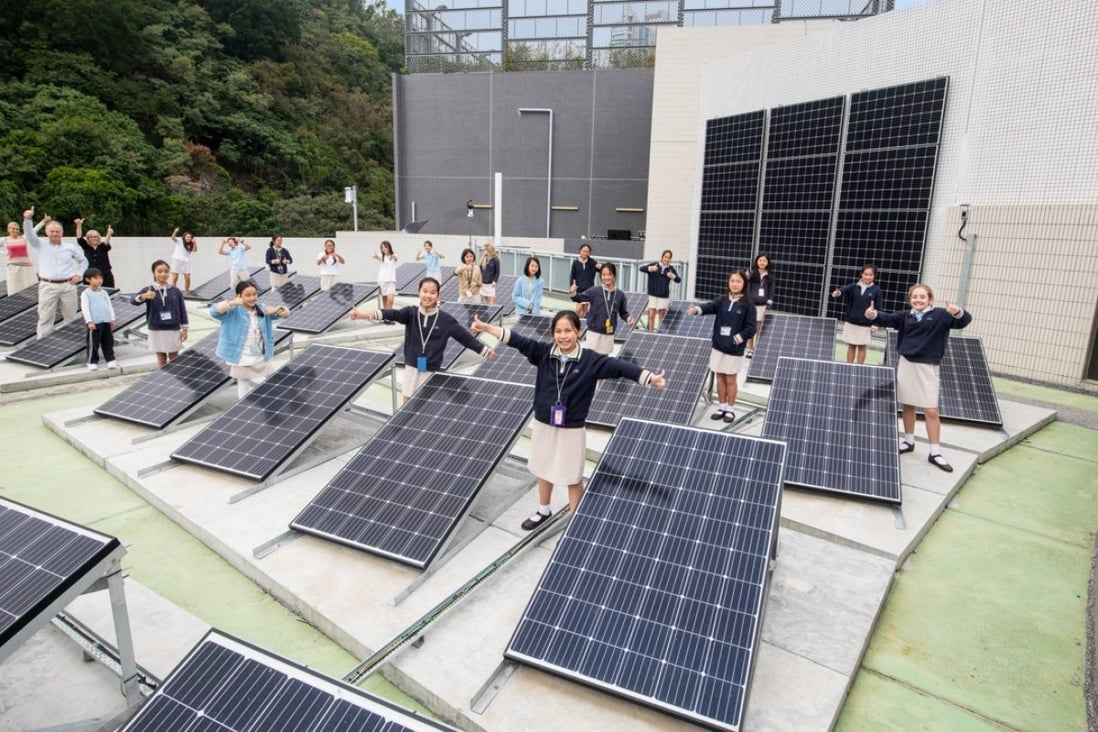 Pupils at The ISF Academy standing among the school’s rooftop solar panels. Photo: Kitmin Lee
