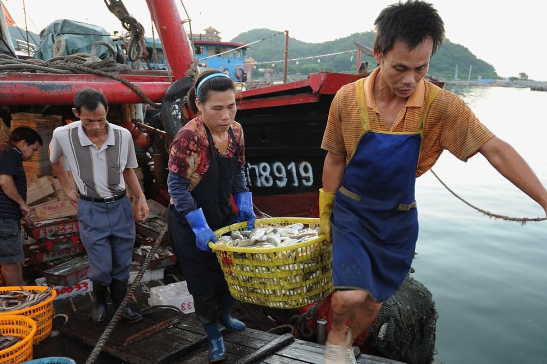 A Chinese fisherman and his wife carry the day’s catch from a boat at a fishing port in Zhuhai in southern China’s Guangdong province. Photo: AFP