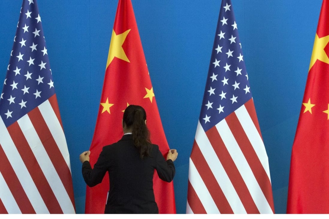 A Chinese woman adjusts a Chinese flag near US flags before a meeting between the countries in Beijing in 2014. Photo: AFP