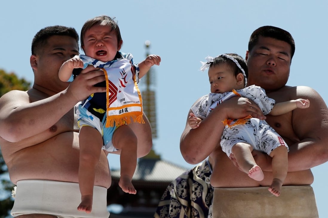 Japanese babies weren’t too impressed when amateur sumo wrestlers held them during a baby crying contest at Sensoji temple in Tokyo. Japan’s birthrate has again fallen below 1 million for the second year in a row, sparking fresh concerns for the country’s population crisis. Photo: Reuters