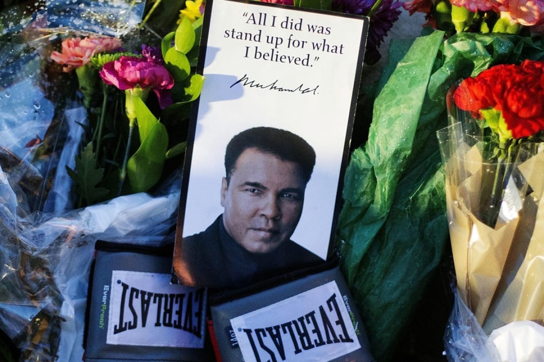 Boxing gloves and a message sit among flowers at a makeshift memorial to Muhammad Ali after he died in 2016 at age 74. President Donald Trump is considering issuing a presidential pardon for Ali, along with some 3,000 others. Photo: AP