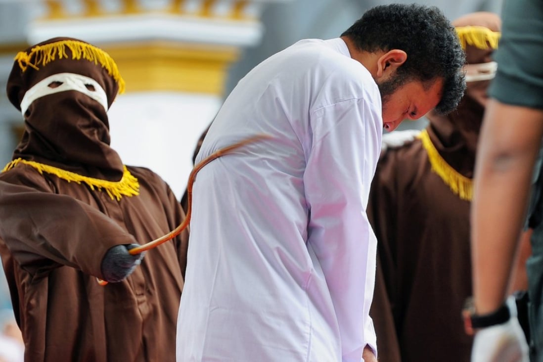 An Indonesian man, one of two to be publicly caned for having sex, is whipped in Banda Aceh. Photo: AFP