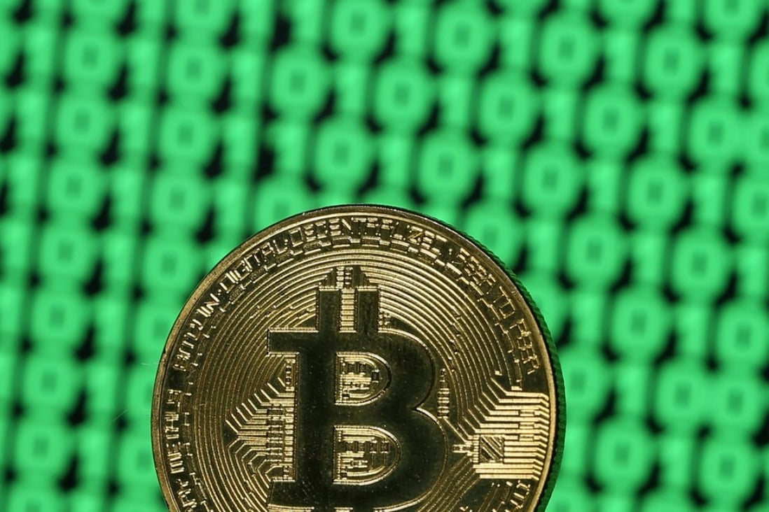 A token of the virtual currency Bitcoin is seen placed on a monitor that displays binary digits. Photo: Reuters