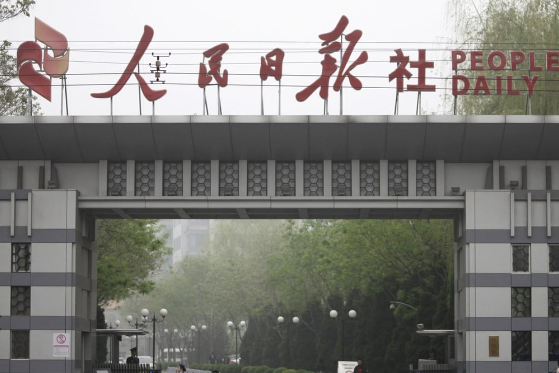A man cycles past the main entrance of People's Daily in Beijing. Photo: Reuters