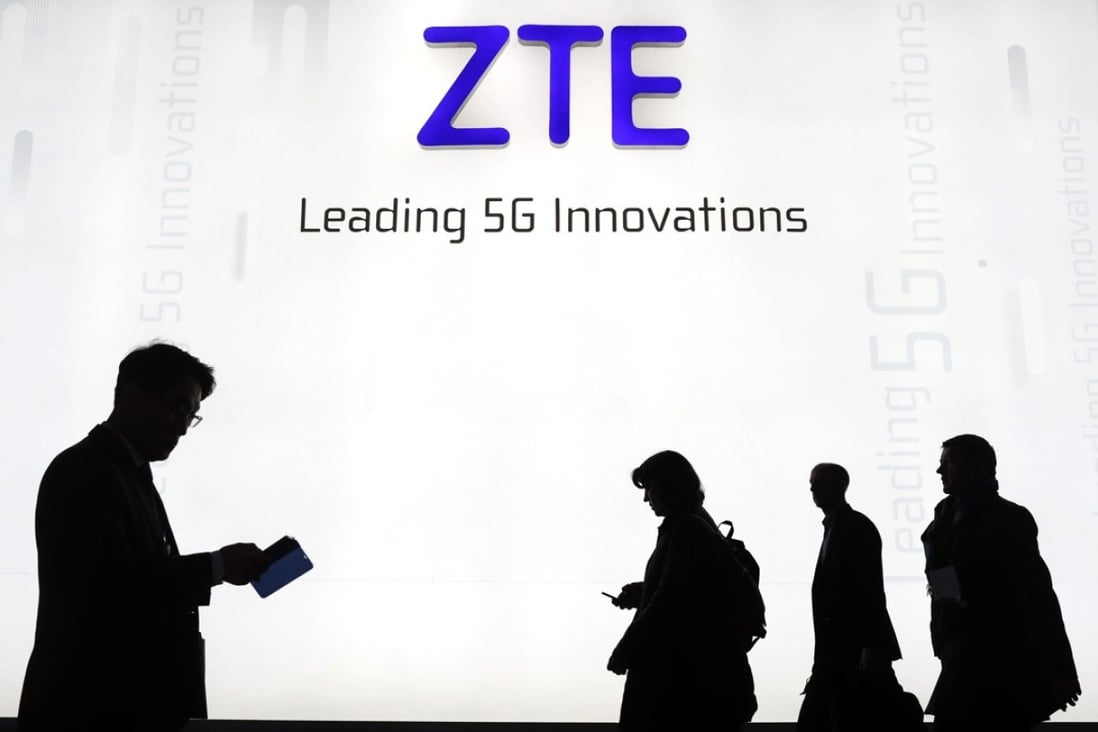 Attendees pass by the ZTE Corp. stand at the Mobile World Congress (MWC) in Barcelona. Photo: Bloomberg