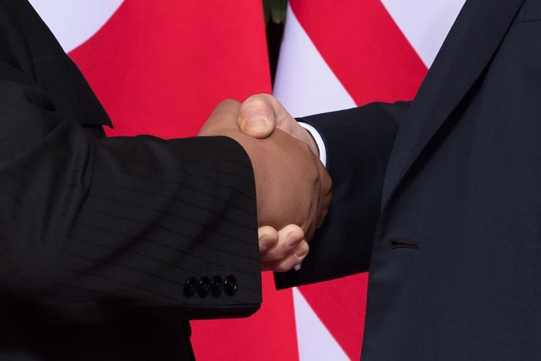 US President Donald Trump and North Korean leader shake hands at the start of their historic summit. Photo: AFP